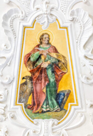 Bruchsal - Peterskirche / St. Peter - Kuppel, Apostelfiguren - Blick auf das Bildnis des Apostels und Evangelisten Johannes; dargestellt mit Evangelienbuch, Adler sowie Kelch (Johannes gilt als der einzige der Apostelschar, der nicht den Märtyrertod gestorben ist) (gemalt von Josef Mariano Kitschker, zwischen 1907 und 1909) (aufgenommen im Mai 2024, am frühen Nachmittag, nach der Renovierung)