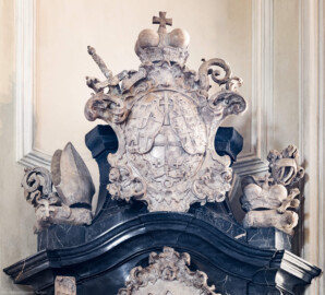 Bruchsal - Peterskirche / St. Peter - Westlicher Chorraum - Doppelgrabdenkmal für Damian Hugo Philipp von Schönborn-Buchheim und für August von Limburg-Stirum -  Von Nordost - Blick auf die bischöflichen Insignien und auf das Allianzwappen Speyer / Weißenburg / Schönborn (ganz oben am Grabdenkmal; Plastik gefertigt von Ferdindanz Diez) (aufgenommen im Mai 2024, am Nachmittag)