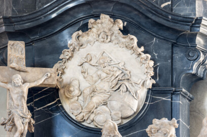 Bruchsal - Peterskirche / St. Peter - Westlicher Chorraum - Doppelgrabdenkmal für Damian Hugo Philipp von Schönborn-Buchheim und für August von Limburg-Stirum -  Von Nordost - Blick auf ein Relief mit Gott Vater, mit der Linken auf die Erdkugel deutend, die Rechte zum Segen erhebend; links daneben eine Skulptur mit Christus am Kreuz auf Golgatha (oben mittig und liks am Grabdenkmal; Plastik gefertigt von Ferdindanz Diez) (aufgenommen im Mai 2024, am Nachmittag)