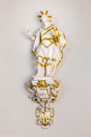 Bruchsal - Peterskirche / St. Peter - Längsschiff / Westwand / Rundnische südlich des nordwestlichen Fensters - Von Nordost - Blick auf eine Figur des Zunftheiligen St. Crispinus und dem Zunftschild der Schuhmacher (aufgenommen im Mai 2024, am späten Nachmittag)