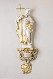 Bruchsal - Peterskirche / St. Peter - Längsschiff / Ostwand / Rundnische südlich des nordöstlichen Fensters - Von Nordwest - Blick auf eine Figur des Zunftheiligen St. Philippus und dem Zunftschild der Walker, Hutmacher und Krämer (?) (aufgenommen im Mai 2024, am späten Nachmittag)