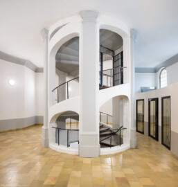 Bad Schönborn / Bad Mingolsheim - Schloss Kislau - Hauptbau - Von Innen - Treppenhaus, Erstes Obergeschoss - Von Osten - Blick vom östlichen Flur nach Westen im ersten Obergeschoss auf das Treppenhaus des ehemaligen Bergfrieds; rechts hinter der Wand befinden sich Büroräume  (aufgenommen im Mai 2024, um die Mittagszeit)