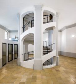 Bad Schönborn / Bad Mingolsheim - Schloss Kislau - Hauptbau - Von Innen - Treppenhaus, Erstes Obergeschoss - Von Westen - Blick vom westlichen Flur nach Osten im ersten Obergeschoss auf das Treppenhaus des ehemaligen Bergfrieds; links hinter der Wand befinden sich Büroräume  (aufgenommen im Mai 2024, am frühen Nachmittag)