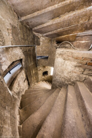 Bad Schönborn / Bad Mingolsheim - Schloss Kislau - Hauptbau - Von Innen - Treppenhaus, Keller - Blick von der oberen Kellertreppe nach unten auf die Wendeltreppe (unten) sowie (Mitte rechts) auf das Treppenauge (der innere Zylinder vom Kellerboden bis zur Kellerdecke, um den sich die Treppe windet) (aufgenommen im Mai 2024, um die Mittagszeit)