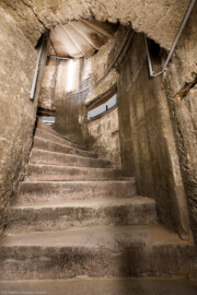 Bad Schönborn / Bad Mingolsheim - Schloss Kislau - Hauptbau - Von Innen - Treppenhaus, Keller - Blick vom unteren Ende der Kellertreppe nach oben auf die Wendeltreppe (Mitte) sowie (links) auf das Treppenauge (der innere Zylinder vom Kellerboden bis zur Kellerdecke, um den sich die Treppe windet) (aufgenommen im Mai 2024, um die Mittagszeit)