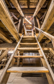 Bad Schönborn / Bad Mingolsheim - Schloss Kislau - Hauptbau - Von Innen - Dachstuhl - Obere Ebene (Ebene 3 von 4) - Von Norden - Blick auf die Treppe zur obersten Ebene (Ebene 4 von 4) des Dachstuhls mit dem Zugang zur Turmuhr und zum Glockenturm; hinter der Treppe befindet sich der Schrank für das Uhrwerk der Turmuhr (aufgenommen im Mai 2024, am Nachmittag)