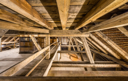 Bad Schönborn / Bad Mingolsheim - Schloss Kislau - Hauptbau - Von Innen - Dachstuhl - Obere Ebene (Ebene 3 von 4) - Von Norden - Blick nach Süden in die Südwestecke des Dachstuhls, auf die obere und nach unten auf die mittlere Ebene (Ebene 2 von 4); links befindet sich der Schrank für das Uhrwerk der Turmuhr (aufgenommen im Mai 2024, am Nachmittag) Bad Schönborn / Bad Mingolsheim - Schloss Kislau - Hauptbau - Von Innen - Dachstuhl - Obere Ebene (Ebene 3 von 4) - Von Norden - Blick nach Süden in die Südwestecke des Dachstuhls, auf die obere und nach unten auf die mittlere Ebene (Ebene 2 von 4); links befindet sich der Schrank für das Uhrwerk der Turmuhr (aufgenommen im Mai 2024, am Nachmittag)