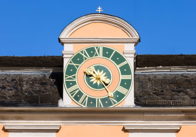 Schloss und Schlossgarten Schwetzingen - Schloss - Mittelbau - Von Westen - Blick auf die zentrale Uhr am Dach; die Zeiger sind aus unbekannten Gründen vertauscht, der große Zeiger zeigt die Stunden, der kleine Zeiger die Minuten an; die Zeiger wurden bis 1968 angetrieben von der alten Turmuhr im Südturm, geschaffen 1763 vom Uhrmacher Johann Jacob Möllinger (1695-1763), der auch das Zifferblatt schuf (Mittelbau: Länge Westseite ca. 45 Meter, Breite Süd-/Nordseite ca. 38 Meter; Wiederaufbau / Erweiterung: 1698-1717; Architekt: Johann Adam Breunig) (aufgenommen im April 2023, am späten Nachmittag)