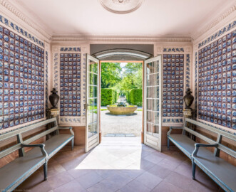 Schloss und Schlossgarten Schwetzingen - Garten - Porzellanhaus - Von innen - Hauptraum - Von Norden - Blick von der nördlichen Tür nach Süden in den Raum und in den Garten; an den Wänden Landschaftsfliesen ("Delfter Porzellan", blaue Bemalung, Format 13 x 13 cm, aus einer Rotterdamer Fayencewerkstatt); in den Ecken vier Vasen (Bildhauer: Johann Matthäus van den Branden (1716-1788) zugeschrieben, Material: Blei, Höhe: ca. 60 cm); an den Seiten zwei Bänke zum Ausruhen; vor der Tür die Wasserglocke (ein Brunnen) (Bau: Grundfläche ca. 9 x 9 Meter; Bauzeit: 1762-1764; Architekt: Nicolas de Pigage; Anzahl Fliesen im Porzellanhaus: 1234, davon 1199 Originale; 930 Landschaftsfliesen mit 65 Motiven und 304 Reiterfliesen mit 26 Motiven; Fliesen ursprünglich in der Alten Orangerie verbaut, danach teilweise im Porzellanhaus wiederverwendet; Erwerb von insgesamt 35.000 Fliesen in den Jahren 1723 und 1727) (aufgenommen im Mai 2023, am frühen Nachmittag) Schloss und Schlossgarten Schwetzingen - Garten - Porzellanhaus - Von innen - Hauptraum - Von Norden - Blick von der nördlichen Tür nach Süden in den Raum und in den Garten; an den Wänden Landschaftsfliesen ("Delfter Porzellan", blaue Bemalung, Format 13 x 13 cm, aus einer Rotterdamer Fayencewerkstatt); in den Ecken vier Vasen (Bildhauer: Johann Matthäus van den Branden (1716-1788) zugeschrieben, Material: Blei, Höhe: ca. 60 cm); an den Seiten zwei Bänke zum Ausruhen; vor der Tür die Wasserglocke (ein Brunnen) (Bau: Grundfläche ca. 9 x 9 Meter; Bauzeit: 1762-1764; Architekt: Nicolas de Pigage; Anzahl Fliesen im Porzellanhaus: 1234, davon 1199 Originale; 930 Landschaftsfliesen mit 65 Motiven und 304 Reiterfliesen mit 26 Motiven; Fliesen ursprünglich in der Alten Orangerie verbaut, danach teilweise im Porzellanhaus wiederverwendet; Erwerb von insgesamt 35.000 Fliesen in den Jahren 1723 und 1727) (aufgenommen im Mai 2023, am frühen Nachmittag)