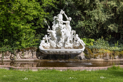 Schloss und Schlossgarten Schwetzingen - Garten - Seepferdgarten - Seepferdgruppe - Von Nordwest - Blick auf die Seepferdgruppe; Tritonen (Wasserwesen der griechischen Sage, je zur Hälfte bestehend aus einem menschlichen Oberkörper und fischartigem Unterkörper mit Schwanzflosse) bekämpfen zwei wilde Wasserrösser (Bildhauer: Gabriel Grupello (1644-1730) zugeschrieben; Datierung: 1709 bis 1716; Versetzung um 1824 in den Westflügel des Karlsruher Schlossgartens; 1994 in Karlsruhe abgebaut, 1996 durch Kopie aus Epoxidharz ersetzt; Original heute im Südlichen Zirkel ausgestellt; zweite Kopie ebenso 1996 am Originalstandort im Seepferdgarten aufgestellt) (aufgenommen im Mai 2023, am späten Nachmittag) Schloss und Schlossgarten Schwetzingen - Garten - Seepferdgarten - Seepferdgruppe - Von Nordwest - Blick auf die Seepferdgruppe; Tritonen (Wasserwesen der griechischen Sage, je zur Hälfte bestehend aus einem menschlichen Oberkörper und fischartigem Unterkörper mit Schwanzflosse) bekämpfen zwei wilde Wasserrösser (Bildhauer: Gabriel Grupello (1644-1730) zugeschrieben; Datierung: 1709 bis 1716; Versetzung um 1824 in den Westflügel des Karlsruher Schlossgartens; 1994 in Karlsruhe abgebaut, 1996 durch Kopie aus Epoxidharz ersetzt; Original heute im Südlichen Zirkel ausgestellt; zweite Kopie ebenso 1996 am Originalstandort im Seepferdgarten aufgestellt) (aufgenommen im Mai 2023, am späten Nachmittag)