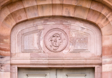Schloss und Schlossgarten Schwetzingen - Garten - Südlicher Zirkelbau - Östlicher Eck-Pavillon - Nordportal - Blick nach oben auf das Nordportal, auf die Bögen oberhalb der großen Tür sowie auf auf das Monogramm "CT" (Carl Theodor) (Gesamter Bau: Länge Bogen ca. 175 Meter, Breite zwischen ca. 11 und 18 Meter, 51 Achsen, 5 Pavillons, 4 Zwischenbauten; Architekt: Franz Wilhelm Rabaliatti; Bauzeit: 1753-1754) (aufgenommen im Mai 2023, am Nachmittag) Schloss und Schlossgarten Schwetzingen - Garten - Südlicher Zirkelbau - Östlicher Eck-Pavillon - Nordportal - Blick nach oben auf das Nordportal, auf die Bögen oberhalb der großen Tür sowie auf auf das Monogramm "CT" (Carl Theodor) (Gesamter Bau: Länge Bogen ca. 175 Meter, Breite zwischen ca. 11 und 18 Meter, 51 Achsen, 5 Pavillons, 4 Zwischenbauten; Architekt: Franz Wilhelm Rabaliatti; Bauzeit: 1753-1754) (aufgenommen im Mai 2023, am Nachmittag)