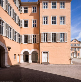 Schloss und Schlossgarten Schwetzingen - Schloss - Mittelbau - Hofseite - Von Süden - Blick auf die Südfassade des nördlichen Teils des Mittelbaus; rechts die Südfassade des Nordflügels / Hofdamenflügels (Mittelbau: Länge Westseite ca. 45 Meter, Breite Süd-/Nordseite ca. 38 Meter; Wiederaufbau / Erweiterung: 1698-1717; Architekt: Johann Adam Breunig) (aufgenommen im Mai 2023, am späten Vormittag)