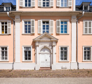 Schloss und Schlossgarten Schwetzingen - Schloss - Nordflügel / Hofkavaliersflügel - Längsbau - Von Süden - Blick vom Ehrenhof nach Norden auf den Mittelrisalit der Südfassade des Nordflügels (Nordflügel: L-förmig, Länge x Breite Längsbau ca. 50 x 14 Meter, Querbau ca. 15 x 12 Meter; Architekt: Johann Adam Breunig (1660-1727); Fertigstellung: 1710) (aufgenommen im Mai 2023, um die Mittagszeit)