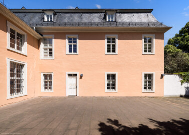 Schloss und Schlossgarten Schwetzingen - Schloss - Küchenflügel / Küchenbau - Längsbau - Von Westen - Blick auf die Westfassade des Längsbaus; links die Südfassade des Verbindungsbaus zwischen dem Küchenflügel und dem Südlichen Zirkelbau (Küchenflügel: L-förmig, Länge x Breite Längsbau ca. 75 x 13 Meter, Querbau ca. 25 x 11 Meter; Architekt: Nicolas de Pigage (1723-1796); Fertigstellung: 1761, letzte Renovierung: 2009-2012) (aufgenommen im Mai 2023, am Nachmittag)
