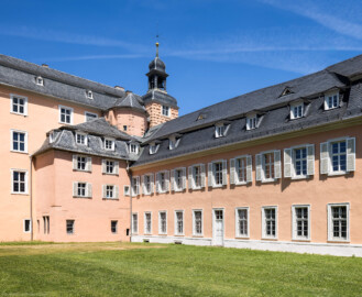 Schloss und Schlossgarten Schwetzingen - Schloss - Mittelbau / Südflügel - Von Südwest - Blick auf die Südfassade des Mittelbaus (ganz links), den südlichen Abau (links), den achteckigen Treppenturm (rechts des Anbaus, oben), den Südturm mit dem Dachreiter, den Glocken und dem Hemmerscher Fünfspitz ((Mitte, oben)) sowie auf die Westfassade des Südflügels (rechts); die fünf linken unteren Fenster und die Tür gehören zum Querbau des Südflügels, die nächsten vier Fenster bis zum Pilaster gehören zum Längsbau des Südflügels (Mittelbau: Länge Westseite ca. 45 Meter, Breite Süd-/Nordseite ca. 38 Meter; Wiederaufbau / Erweiterung: 1698-1717; Architekt: Johann Adam Breunig) (aufgenommen im Mai 2023, am Nachmittag Schloss und Schlossgarten Schwetzingen - Schloss - Mittelbau / Südflügel - Von Südwest - Blick auf die Südfassade des Mittelbaus (ganz links), den südlichen Abau (links), den achteckigen Treppenturm (rechts des Anbaus, oben), den Südturm mit dem Dachreiter, den Glocken und dem Hemmerscher Fünfspitz ((Mitte, oben)) sowie auf die Westfassade des Südflügels (rechts); die fünf linken unteren Fenster und die Tür gehören zum Querbau des Südflügels, die nächsten vier Fenster bis zum Pilaster gehören zum Längsbau des Südflügels (Mittelbau: Länge Westseite ca. 45 Meter, Breite Süd-/Nordseite ca. 38 Meter; Wiederaufbau / Erweiterung: 1698-1717; Architekt: Johann Adam Breunig) (aufgenommen im Mai 2023, am Nachmittag