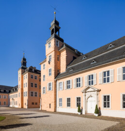 Schloss und Schlossgarten Schwetzingen - Schloss - Mittelbau - Hofseite - Von Nordost - Blick vom Nordflügel nach Südwesten auf die Schlosskapelle mit dem Portal (rechts), den Mittelbau mit dem Nord- und Südturm (Mitte) sowie auf den Südflügel (links) (Mittelbau: Länge Westseite ca. 45 Meter, Breite Süd-/Nordseite ca. 38 Meter; Wiederaufbau / Erweiterung: 1698-1717; Architekt: Johann Adam Breunig) (aufgenommen im Juni 2023, am Vormittag)