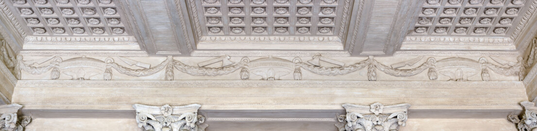Schloss und Schlossgarten Schwetzingen - Garten - Minervatempel - Von innen - Rückwand, Fries oberhalb der Kapitelle - Blick auf Verzierungen des umlaufenden Frieses; drei Deckelvasen mit Blattgirlanden, in den Girlandenmulden Opferwerkzeuge (Messer und Beile) (Gesamter Bau: Breite ca. 7 Meter, Länge ca. 9 Meter, Innenraum kubisch; Rückseite zweigeschossig mit Kellerraum; Architekt: Nicolas de Pigage (1723-1796); Bauzeit: vermutlich zwischen 1767/68 und 1773) (aufgenommen im Juni 2023, am frühen Nachmittag) Schloss und Schlossgarten Schwetzingen - Garten - Minervatempel - Von innen - Rückwand, Fries oberhalb der Kapitelle - Blick auf Verzierungen des umlaufenden Frieses; drei Deckelvasen mit Blattgirlanden, in den Girlandenmulden Opferwerkzeuge (Messer und Beile) (Gesamter Bau: Breite ca. 7 Meter, Länge ca. 9 Meter, Innenraum kubisch; Rückseite zweigeschossig mit Kellerraum; Architekt: Nicolas de Pigage (1723-1796); Bauzeit: vermutlich zwischen 1767/68 und 1773) (aufgenommen im Juni 2023, am frühen Nachmittag)