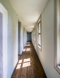 Schloss und Schlossgarten Schwetzingen - Schloss - Nordflügel, Nord-Süd-Teil - Schlosskapelle - Gang zur Orgelempore - Von Norden - Blick nach Süden in den Gang vom Ersten Vorzimmer des ersten Obergeschosses des Mittelbaus zur Orgelempore; ganz vorne links die Tür zur Orgelempore, ganz hinten die Tür zum Ersten Vorzimmer (Schlosskapelle: Länge ca. 14 Meter, Breite ca. 10 Meter, Höhe: bis unter das Dach, Achsen: 6, Eingang: Ostseite; Bauzeit: zwischen 1698 und 1715; Architekten: Johann Adam Breunig, Simon Sarto; Umbau innen im klassizistischen Stil und Einbau einer Orgelempore: 1804-1806, Architekt: Friedrich Weinbrenner) (aufgenommen im Juni 2023, am Nachmittag)