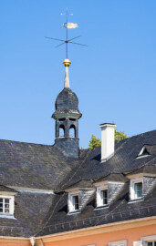 Schloss und Schlossgarten Schwetzingen - Schloss - Nordflügel / Hofkavaliersflügel - Von Südost - Blick vom Ehrenhof auf den Dachreiter in der Nordwestecke des Nordflügels; oben ein Hemmerscher Fünfspitz mit einer Wetterfahne (Wappen der Kurpfalz), darunter ein Turmknopf, darunter eine Welsche Haube, darunter die Laterne (NordFlügel: L-förmig, Länge x Breite Längsbau ca. 50 x 14 Meter, Querbau ca. 15 x 12 Meter; Architekt: Johann Adam Breunig (1660-1727); Fertigstellung: 1710) (aufgenommen im Juli 2023, am Vormittag)