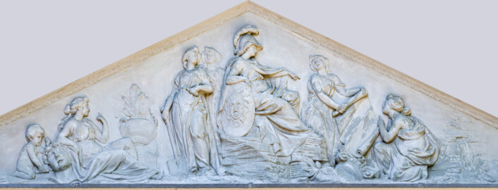 Schloss und Schlossgarten Schwetzingen - Garten - Minervatempel - Tympanon - Von aussen - Vorderseite - Von Nordost - Reliefdarstellung der Göttin Minerva als Beschützerin der Gartenkunst; Relief geschaffen 1769 von Franz Conrad Linck (1730-1793), nach einer Vorlage von Peter Anton von Verschaffelt (1710-1793) am Bibliotheksbau von Schloss Mannheim; in der Mitte: Minerva, auf einem Steinhaufen sitzend, mit Helm und Schild, auf eine Papierrolle zeigend; rechts: zwei Frauen, die Papierrolle haltend; ganz rechts: ein Fels mit einem Wasserquelle; links: zwei Frauen, eine mit Sichel und Spaten; links davon: eine weitere Frau, sitzend, den Arm auf einen Steinkopf stützend; ganz links: ein Putto mit Hammer und Meisel, den Stein  bearbeitend (Hintergrund stark, Figuren schwach retuschiert, Kontraste verstärkt) (aufgenommen im Juli 2023, um die Mittagszeit)