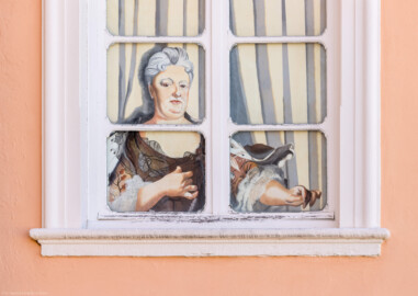 Schloss und Schlossgarten Schwetzingen - Schloss - Mittelbau - Südlicher Eckpavillon - Von Norden - Blick auf das Nordfenster im 1. Obergeschoss des südlichen Eckpavillons; dahinter befand sich das Grosse Cabinet der Kurfürstin ; Elisabeth Auguste (eine gemalte Figur) blickt auf die Terrasse herunter (Mittelbau: Länge Westseite ca. 45 Meter, Breite Süd-/Nordseite ca. 38 Meter; Wiederaufbau / Erweiterung: 1698-1717; Architekt: Johann Adam Breunig) (aufgenommen im August 2023, um die Mittagszeit)