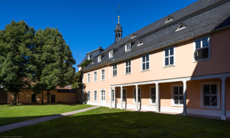 Schloss und Schlossgarten Schwetzingen - Schloss - Nordflügel / Hofkavaliersflügel - Von Südwest - Blick von der Nordwand des Mittelbaus auf die Westfassaden des Querbaus und des Längsbaus des Nordflügels; in der Nordwestecke der Dachreiter mit einem Hemmerschen Fünfspitz; im Hintergrund das Dach des Oberen Wasserwerks (NordFlügel: L-förmig, Länge x Breite Längsbau ca. 50 x 14 Meter, Querbau ca. 15 x 12 Meter; Architekt: Johann Adam Breunig (1660-1727); Fertigstellung: 1710) (aufgenommen im August 2023, am späten Nachmittag)