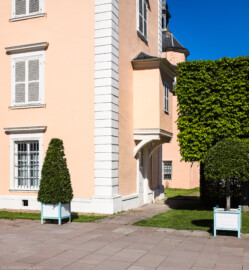 Schloss und Schlossgarten Schwetzingen - Schloss - Mittelbau - Südlicher Eckpavillon - Von Südwest - Blick auf den Eingang sowie auf den Erker im 1. Obergeschoss des südlichen Eckpavillons; der Erker war Teil des Kleinen Schreibzimmers von Elisabeth Auguste von Pfalz-Sulzbach (Mittelbau: Länge Westseite ca. 45 Meter, Breite Süd-/Nordseite ca. 38 Meter; Wiederaufbau / Erweiterung: 1698-1717; Architekt: Johann Adam Breunig) (aufgenommen im August 2023, am späten Nachmittag)