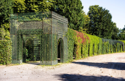 Schloss und Schlossgarten Schwetzingen - Garten - Kreisparterre - Nördlicher Laubengang, Südwestende - Von Südost - Blick nach Nordwesten auf einen Ausschnitt des nördlichen Laubengangs (Berceaux de Treillage) mit portalartigen Eingängen; die Laubengänge sind mit wildem Wein und blühenden Kletterpflanzen bepflanzt (aufgenommen im August 2023, am späten Vormittag)