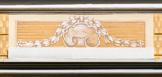 Schloss und Schlossgarten Schwetzingen - Garten - Badhaus - Von aussen - Westseite - Feld, Mittelrisalit, oben - Von Westen - Blick auf ein Feld mit einer Jakobsmuschel und umliegendem Lorbeerkranz, ockerfarben gemalt in Camaieuxtechnik, Hintergrund weißgelb-ocker (Gesamter Bau: Länge x Breite ca. 18 x 15 Meter, Höhe ca. 11 Meter; Architekt: Nicolas de Pigage (1723-1796); Bauzeit: 1768-1772; Gesamtinstandsetzung innen und außen: 1999-2006) (aufgenommen im August 2023, am späten Nachmittag) Schloss und Schlossgarten Schwetzingen - Garten - Badhaus - Von aussen - Westseite - Feld, Mittelrisalit, oben - Von Westen - Blick auf ein Feld mit einer Jakobsmuschel und umliegendem Lorbeerkranz, ockerfarben gemalt in Camaieuxtechnik, Hintergrund weißgelb-ocker (Gesamter Bau: Länge x Breite ca. 18 x 15 Meter, Höhe ca. 11 Meter; Architekt: Nicolas de Pigage (1723-1796); Bauzeit: 1768-1772; Gesamtinstandsetzung innen und außen: 1999-2006) (aufgenommen im August 2023, am späten Nachmittag)