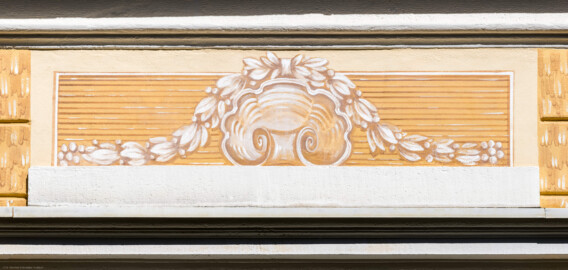 Schloss und Schlossgarten Schwetzingen - Garten - Badhaus - Von aussen - Westseite - Feld, Mittelrisalit, oben - Von Westen - Blick auf ein Feld mit einer Jakobsmuschel und umliegendem Lorbeerkranz, ockerfarben gemalt in Camaieuxtechnik, Hintergrund weißgelb-ocker (Gesamter Bau: Länge x Breite ca. 18 x 14 Meter, Höhe ca. 10 Meter; Architekt: Nicolas de Pigage (1723-1796); Bauzeit: 1768-1772; Gesamtinstandsetzung innen und außen: 1999-2006) (aufgenommen im August 2023, am späten Nachmittag) Schloss und Schlossgarten Schwetzingen - Garten - Badhaus - Von aussen - Westseite - Feld, Mittelrisalit, oben - Von Westen - Blick auf ein Feld mit einer Jakobsmuschel und umliegendem Lorbeerkranz, ockerfarben gemalt in Camaieuxtechnik, Hintergrund weißgelb-ocker (Gesamter Bau: Länge x Breite ca. 18 x 14 Meter, Höhe ca. 10 Meter; Architekt: Nicolas de Pigage (1723-1796); Bauzeit: 1768-1772; Gesamtinstandsetzung innen und außen: 1999-2006) (aufgenommen im August 2023, am späten Nachmittag)