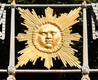 Schloss und Schlossgarten Schwetzingen - Garten - Anlage Apollotempel - Von außen - Von Süden - Blick auf ein Sonnengesicht, ein vergoldetes Relief, am Geländer auf der Nordseite der oberen Terrasse, Symbol für Apollo als Gott des Lichtes und der Ordnung (Anlage: Länge x Breite: ca. 30 x 20 Meter; Bauzeit: 1762-1777; Architekt: Nicolas de Pigage) (aufgenommen im September 2023, am frühen Nachmittag)