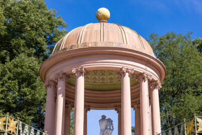 Schloss und Schlossgarten Schwetzingen - Garten - Apollotempel - Von außen - Von Westen - Blick von der unteren Terrasse (dem Belvedere) auf  die Kuppel (mit Blei gedeckt, oben mit einem kugelförmigen Knauf, innen mit einer Kassettendecke), den oberen Teil des Rundtempels (Monopteros) des Apollo (mit zwölf Säulen ionischer Säulenordnung, ohne Cella) sowie auf die Statue des Apollo beim linkshändigen Lyra-Spiel (Skulptur geschaffen von Peter Anton von Verschaffelt, vor 1773) (Anlage: Länge x Breite: ca. 30 x 20 Meter; Bauzeit: 1762-1777; Architekt: Nicolas de Pigage) (aufgenommen im September 2023, am Nachmittag)
