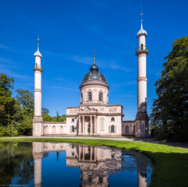 Schloss und Schlossgarten Schwetzingen - Garten - Moschee - Von außen - Von Südwest - Blick vom südöstlichen Rand des Moscheeweihers nach Nordost auf die Westfassade der Moschee; in der Mitte das Hauptgebäude mit dem Portikus, über dem Kubus der Tambour und die Kuppel, links und rechts die beiden Minarette (Moschee: Länge mit Minaretten und Verbindungsbau zum Kreuzgang ca. 44 Meter, Breite ca. 29 Meter; Bauzeit: 1782-1795; Architekt: Nicolas de Pigage; Gesamtrestaurierung Moscheeanlage: ca. 1995 bis 2007) (aufgenommen im September 2023, am Nachmittag)