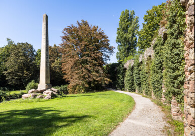 Schloss und Schlossgarten Schwetzingen - Garten - Obelisk, Nähe Römischem Wasserkastell - Von Osten - Blick vom östlichen Aquädukt auf den Obelisken; der Obelisk dient als Denkmal für die in einer angenommenen Schlacht zwischen Römern und Germanen Gefallenen; die Skulptur markiert den Fundort von römisch-germanischen Gräbern, entdeckt 1777 bei Erdarbeiten zur Anlage des Arboretums (Obelisk: Höhe: ca. ? Meter; Bauzeit: 1779; Architekt: Nicolas de Pigage) (aufgenommen im September 2023, um die Mittagszeit) Schloss und Schlossgarten Schwetzingen - Garten - Obelisk, Nähe Römischem Wasserkastell - Von Osten - Blick vom östlichen Aquädukt auf den Obelisken; der Obelisk dient als Denkmal für die in einer angenommenen Schlacht zwischen Römern und Germanen Gefallenen; die Skulptur markiert den Fundort von römisch-germanischen Gräbern, entdeckt 1777 bei Erdarbeiten zur Anlage des Arboretums (Obelisk: Höhe: ca. ? Meter; Bauzeit: 1779; Architekt: Nicolas de Pigage) (aufgenommen im September 2023, um die Mittagszeit)
