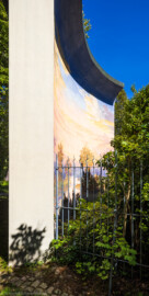 Schloss und Schlossgarten Schwetzingen - Garten - Badhausanlage - Perspektiv - Von Westen - Blick hinter der westlichen Umfassungsmauer der Badhausanlage nach Osten auf die gewölbte Wand mit der gemalten Landschaft des Perspektivs ("Das Ende der Welt"); Fresko ursprünglich erstellt von dem Mannheimer Theatermaler Truckenmüller nach einer Vorlage von Ferdinand Kobell (1740-1799) (Perspektiv: Abmessungen Länge x Breite x Höhe: Laubengang ca. 40 x 3,5 x 4,5 Meter, Bau ca. 16 x 4,5 bis 11 x 6,5 Meter, Bildwand ca. 9 x 1 x 7,5 Meter; Fertigstellung: 1775, Gesamtinstandsetzung: 1988-1991, Restaurierung Laubengang: 2022; Architekt: Nicolas de Pigage) (aufgenommen im September 2023, am frühen Nachmittag)