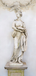 Schloss und Schlossgarten Schwetzingen - Garten - Tempel der Botanik - Von innen - Skulptur Botanik - Von Osten - Blick auf die Skulptur der Botanik, gehauen von Francesco Carabelli (1737-1798), gekauft 1775 in Italien; ursprünglich stellte die Skulptur Ceres / Demeter dar, die Göttin des Ackerbaus und der Fruchtbarkeit, die ein Ährenbündel in ihrem Arm hielt; die Skulptur wurde umgearbeitet zur Botanik, die in ihrem linken Arm ein Bündel Papiere hielt, beschriftet mit "Caroli Linnei sistema plantarum", ein Hinweis auf die beiden bedeutsamsten Werke "Species Plantarum" und "Systema Naturae" von Carl von Linné (1707-1778); heute ist das Manuskript im linken Arm nicht mehr vorhanden (Tempel: Durchmesser ca. 7 Meter; Bauzeit: 1777-1780; Architekt: Nicolas de Pigage) (aufgenommen im September 2023, um die Mittagszeit)