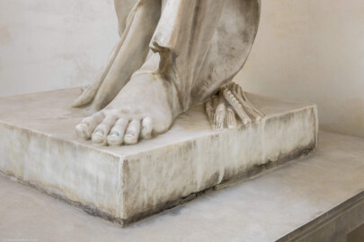Schloss und Schlossgarten Schwetzingen - Garten - Tempel der Botanik - Von innen - Skulptur Botanik - Von Nordost - Blick auf den Fuß der Skulptur der Botanik, unter dem Gewand ein Ährenbündel; Skulptur gehauen von Francesco Carabelli (1737-1798), gekauft 1775 in Italien; ursprünglich stellte die Skulptur Ceres / Demeter dar, die Göttin des Ackerbaus und der Fruchtbarkeit, die ein Ährenbündel in ihrem Arm hielt; die Skulptur wurde umgearbeitet zur Botanik, die in ihrem linken Arm ein Bündel Papiere hielt, beschriftet mit "Caroli Linnei sistema plantarum", ein Hinweis auf die beiden bedeutsamsten Werke "Species Plantarum" und "Systema Naturae" von Carl von Linné (1707-1778); heute ist das Manuskript im linken Arm nicht mehr vorhanden (Tempel: Durchmesser ca. 7 Meter; Bauzeit: 1777-1780; Architekt: Nicolas de Pigage) (aufgenommen im September 2023, am frühen Nachmittag)