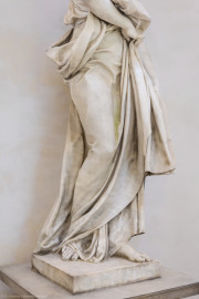 Schloss und Schlossgarten Schwetzingen - Garten - Tempel der Botanik - Von innen - Skulptur Botanik - Von Südost - Blick auf den Faltenwurf des Gewands der Skulptur der Botanik, gehauen von Francesco Carabelli (1737-1798), gekauft 1775 in Italien; ursprünglich stellte die Skulptur Ceres / Demeter dar, die Göttin des Ackerbaus und der Fruchtbarkeit, die ein Ährenbündel in ihrem Arm hielt; die Skulptur wurde umgearbeitet zur Botanik, die in ihrem linken Arm ein Bündel Papiere hielt, beschriftet mit "Caroli Linnei sistema plantarum", ein Hinweis auf die beiden bedeutsamsten Werke "Species Plantarum" und "Systema Naturae" von Carl von Linné (1707-1778); heute ist das Manuskript im linken Arm nicht mehr vorhanden (Tempel: Durchmesser ca. 7 Meter; Bauzeit: 1777-1780; Architekt: Nicolas de Pigage) (aufgenommen im September 2023, am frühen Nachmittag) Schloss und Schlossgarten Schwetzingen - Garten - Tempel der Botanik - Von innen - Skulptur Botanik - Von Südost - Blick auf den Faltenwurf des Gewands der Skulptur der Botanik, gehauen von Francesco Carabelli (1737-1798), gekauft 1775 in Italien; ursprünglich stellte die Skulptur Ceres / Demeter dar, die Göttin des Ackerbaus und der Fruchtbarkeit, die ein Ährenbündel in ihrem Arm hielt; die Skulptur wurde umgearbeitet zur Botanik, die in ihrem linken Arm ein Bündel Papiere hielt, beschriftet mit "Caroli Linnei sistema plantarum", ein Hinweis auf die beiden bedeutsamsten Werke "Species Plantarum" und "Systema Naturae" von Carl von Linné (1707-1778); heute ist das Manuskript im linken Arm nicht mehr vorhanden (Tempel: Durchmesser ca. 7 Meter; Bauzeit: 1777-1780; Architekt: Nicolas de Pigage) (aufgenommen im September 2023, am frühen Nachmittag)