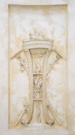 Schloss und Schlossgarten Schwetzingen - Garten - Tempel der Botanik - Von innen - Unteres großes Wandfeld, Südwestseite - Blick auf ein Stuckrelief, den Frühling symbolisierend mittels zweier Harken mit Blütenzweigen; in der Mitte ein Dreifuß mit hochaufgerichteter Schlange, oben eine Schale mit brennendem Feuer; Stuckateur Joseph Anton Pozzi (1732-1811) (Tempel: Durchmesser ca. 7 Meter; Bauzeit: 1777-1780; Architekt: Nicolas de Pigage) (aufgenommen im September 2023, am späten Vormittag)