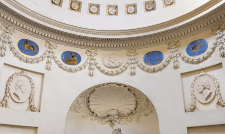 Schloss und Schlossgarten Schwetzingen - Garten - Tempel der Botanik - Von innen - Raum, Ausschnitt - Von Osten - Blick vom Eingang nach Westen (Richtung Skulptur der Botanik) und nach oben; unten mittig eine Muschel, umgeben von zwei gekreuzten Eichenlaubzweigen und Blüten; links (südlich) und rechts (nördlich) zwei stuckierte Reliefporträts von Naturforschern, links Carl von Linné (1707-1778), rechts Joseph Pitton de Tournefort (1656-1708); unterhalb der Kuppel Girlanden, dazwischen vier Tierkreiszeichen (von links: Löwe, Jungfrau, Waage, Skorpion) und mittig ein Jahreszeiten-Medaillon (Stuckrelief mit Putto, Sichel und Getreide, den Sommer symbolisierend); darüber ein Kranzgesims (mit Blattstab, Zahnschnittfries, Perlstab, Eierstab, Guttae, Karnies); in der Kuppel rosettengeschmückte kleine Kassetten (Tempel: Durchmesser ca. 7 Meter; Bauzeit: 1777-1780; Architekt: Nicolas de Pigage) (aufgenommen im September 2023, am frühen Nachmittag) Schloss und Schlossgarten Schwetzingen - Garten - Tempel der Botanik - Von innen - Raum, Ausschnitt - Von Osten - Blick vom Eingang nach Westen (Richtung Skulptur der Botanik) und nach oben; unten mittig eine Muschel, umgeben von zwei gekreuzten Eichenlaubzweigen und Blüten; links (südlich) und rechts (nördlich) zwei stuckierte Reliefporträts von Naturforschern, links Carl von Linné (1707-1778), rechts Joseph Pitton de Tournefort (1656-1708); unterhalb der Kuppel Girlanden, dazwischen vier Tierkreiszeichen (von links: Löwe, Jungfrau, Waage, Skorpion) und mittig ein Jahreszeiten-Medaillon (Stuckrelief mit Putto, Sichel und Getreide, den Sommer symbolisierend); darüber ein Kranzgesims (mit Blattstab, Zahnschnittfries, Perlstab, Eierstab, Guttae, Karnies); in der Kuppel rosettengeschmückte kleine Kassetten (Tempel: Durchmesser ca. 7 Meter; Bauzeit: 1777-1780; Architekt: Nicolas de Pigage) (aufgenommen im September 2023, am frühen Nachmittag)