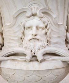 Schloss und Schlossgarten Schwetzingen - Garten - Tempel der Botanik - Von innen - Südliche Vase - Von Norden - Blick auf einen Ausschnitt der Vase; Vase unten mit Schuppen überzogen, mittig ein bärtiger Männerkopf, links und rechts zwei Schlangenkörper (Bildhauer Postament: Franz Conrad Linck (1730-1793), um 1779; Bildhauer Vase: unklar, evtl. Peter Anton von Verschaffelt (1710-1793), Francesco Carabelli (1737-1798) oder Franz Conrad Linck (1730-1793)) (Tempel: Durchmesser ca. 7 Meter; Bauzeit: 1777-1780; Architekt: Nicolas de Pigage) (aufgenommen im September 2023, um die Mittagszeit) Schloss und Schlossgarten Schwetzingen - Garten - Tempel der Botanik - Von innen - Südliche Vase - Von Norden - Blick auf einen Ausschnitt der Vase; Vase unten mit Schuppen überzogen, mittig ein bärtiger Männerkopf, links und rechts zwei Schlangenkörper (Bildhauer Postament: Franz Conrad Linck (1730-1793), um 1779; Bildhauer Vase: unklar, evtl. Peter Anton von Verschaffelt (1710-1793), Francesco Carabelli (1737-1798) oder Franz Conrad Linck (1730-1793)) (Tempel: Durchmesser ca. 7 Meter; Bauzeit: 1777-1780; Architekt: Nicolas de Pigage) (aufgenommen im September 2023, um die Mittagszeit)