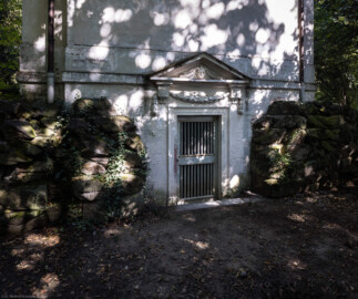 Schloss und Schlossgarten Schwetzingen - Garten - Minervatempel - Von aussen - Rückseite - Von Südwest - Blick auf den unteren Teil der Rückseite des Minervatempels mit den zwei Geschossen und (von unten nach oben) dem Portal zu einem unterirdischen Raum mit zwei Stufen, gerahmter Tür, Rosetten und Girlanden, Dreiecksgiebel mit Maske eines Pans bzw. Fauns, darüber die leere, verputzte Wand (Gesamter Bau: Breite ca. 7 Meter, Länge ca. 9 Meter, Innenraum kubisch; Rückseite zweigeschossig mit Kellerraum; Architekt: Nicolas de Pigage (1723-1796); Bauzeit: vermutlich zwischen 1767/68 und 1773) (aufgenommen im September 2023, am frühen Nachmittag) Schloss und Schlossgarten Schwetzingen - Garten - Minervatempel - Von aussen - Rückseite - Von Südwest - Blick auf den unteren Teil der Rückseite des Minervatempels mit den zwei Geschossen und (von unten nach oben) dem Portal zu einem unterirdischen Raum mit zwei Stufen, gerahmter Tür, Rosetten und Girlanden, Dreiecksgiebel mit Maske eines Pans bzw. Fauns, darüber die leere, verputzte Wand (Gesamter Bau: Breite ca. 7 Meter, Länge ca. 9 Meter, Innenraum kubisch; Rückseite zweigeschossig mit Kellerraum; Architekt: Nicolas de Pigage (1723-1796); Bauzeit: vermutlich zwischen 1767/68 und 1773) (aufgenommen im September 2023, am frühen Nachmittag)