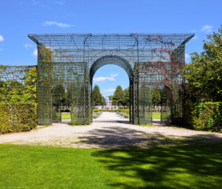 Schloss und Schlossgarten Schwetzingen - Garten - Kreisparterre - Südlicher Laubengang - Von Südwest - Blick vom Tritonenbrunnen nach Nordosten auf einen Ausschnitt des südlichen Laubengangs (Berceaux de Treillage) mit portalartigen Durchgängen; die Laubengänge sind mit Wildem Wein und blühenden Kletterpflanzen bepflanzt (aufgenommen im September 2023, am Nachmittag)
