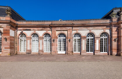 Schloss und Schlossgarten Schwetzingen - Garten - Nördlicher Zirkelbau - Zwischenbau zwischen östlichem Pavillon (links) und östlichem Eck-Pavillon (rechts) - Von Westen - Blick auf einen siebenachsigen Abschnitt des nördlichen Zirkelbaus (Gesamter Bau: Länge Bogen ca. 175 Meter, Breite zwischen ca. 11 und 18 Meter, 51 Achsen, 5 Pavillons, 4 Zwischenbauten; Architekt: Alessandro Alessandro Galli da Bibiena (1686-1748), Bauleitung: zuerst Guillaume d’Hauberat (1680–1749), dann Nicolas de Pigage (1723-1796); Bauzeit: 1748-1750) (aufgenommen im September 2023, am Nachmittag)