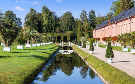 Schloss und Schlossgarten Schwetzingen - Garten - Orangeriegarten, nördlicher Kanal - Von Osten - Blick von der Nordostecke des Orangeriegartens nach Westen auf den Kanal mit der Brücke, rechts die Südfassade der Neuen Orangerie (aufgenommen im Oktober 2023, am späten Vormittag)
