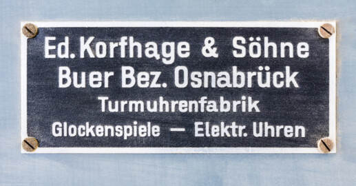 Schloss und Schlossgarten Schwetzingen - Schloss - Mittelbau - Von innen - Dachstuhl, Südseite - Dachzimmer neben/nördlich der Uhrenstube im südlichen Turm - Firmenschild der Firma Eduard Korfhage & Söhne mit Sitz in Buer bei Melle am Unterbau der mechanischen Turmuhr vom Typ UT 6000 (Mittelbau: Länge Westseite ca. 45 Meter, Breite Süd-/Nordseite ca. 38 Meter; Wiederaufbau / Erweiterung: 1698-1717; Architekten: Johann Adam Breunig, Simon Sarto) (aufgenommen im Oktober 2023, am Nachmittag) Schloss und Schlossgarten Schwetzingen - Schloss - Mittelbau - Von innen - Dachstuhl, Südseite - Dachzimmer neben/nördlich der Uhrenstube im südlichen Turm - Firmenschild der Firma Eduard Korfhage & Söhne mit Sitz in Buer bei Melle am Unterbau der mechanischen Turmuhr vom Typ UT 6000 (Mittelbau: Länge Westseite ca. 45 Meter, Breite Süd-/Nordseite ca. 38 Meter; Wiederaufbau / Erweiterung: 1698-1717; Architekten: Johann Adam Breunig, Simon Sarto) (aufgenommen im Oktober 2023, am Nachmittag)