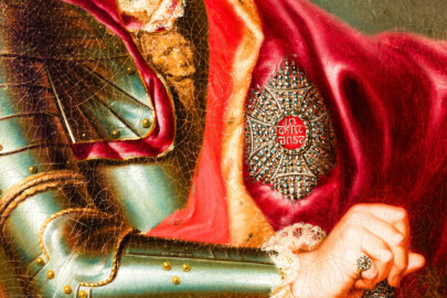 Schloss und Schlossgarten Schwetzingen - Schloss - Mittelbau - Von innen - 1. Obergeschoss - Appartment des Kurfürsten - Erstes Vorzimmer - Westwand, links der Tür zum zweiten Vorzimmer - Ausschnitt aus dem Porträt von Kurfürst Carl Theodor (1724-1799, reg. 1742-1799); gekleidet in einer Paraderüstung mit umgehängtem Mantel, in der Rechten der Marschallstab; an seiner linken Brust ein Bruststern des Ordens des Heiligen Hubertus (kurz Hubertusorden) mit der Abkürzung der Ordensdevise "In Treue fest" als Inschrift; mitten auf der Brust der zum Hausritterorden vom Heiligen Georg (kurz Georgsorden) gehörende Löwenkopf (Maler: Heinrich Carl Brandt (1724-1787); Datierung: um 1767) (aufgenommen im Dezember 2023, am späten Vormittag) Schloss und Schlossgarten Schwetzingen - Schloss - Mittelbau - Von innen - 1. Obergeschoss - Appartment des Kurfürsten - Erstes Vorzimmer - Westwand, links der Tür zum zweiten Vorzimmer - Ausschnitt aus dem Porträt von Kurfürst Carl Theodor (1724-1799, reg. 1742-1799); gekleidet in einer Paraderüstung mit umgehängtem Mantel, in der Rechten der Marschallstab; an seiner linken Brust ein Bruststern des Ordens des Heiligen Hubertus (kurz Hubertusorden) mit der Abkürzung der Ordensdevise "In Treue fest" als Inschrift; mitten auf der Brust der zum Hausritterorden vom Heiligen Georg (kurz Georgsorden) gehörende Löwenkopf (Maler: Heinrich Carl Brandt (1724-1787); Datierung: um 1767) (aufgenommen im Dezember 2023, am späten Vormittag)