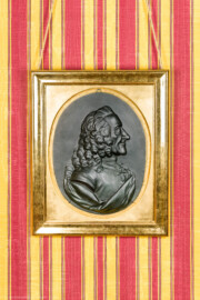 Schloss und Schlossgarten Schwetzingen - Schloss - Mittelbau - Von innen - 1. Obergeschoss - Appartment des Kurfürsten - Konferenzzimmer - Südwand, links der Mitte - Portrait-Relief von Voltaire (1694-1778) (Bildhauer: Franz Conrad Linck (1730-1793), Datierung: 1777; Material: Gips, schwarz gefärbt) (aufgenommen im Januar 2024, am  Nachmittag)