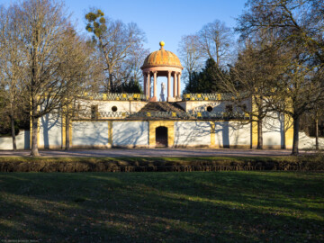 Schloss und Schlossgarten Schwetzingen - Garten - Anlage Apollotempel - Von außen - Von Westen - Blick von der großen Rasenfläche westlich des Kanals auf die Anlage des Apollo-Tempels (Skulptur geschaffen von Peter Anton von Verschaffelt, vor 1773) (Anlage: Länge x Breite: ca. 30 x 20 Meter; Bauzeit: 1762-1777; Architekt: Nicolas de Pigage) (aufgenommen im Januar 2024, am Nachmittag)