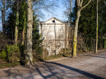 Schloss und Schlossgarten Schwetzingen - Garten - Minervatempel - Von aussen - Rückseite - Von Südwest - Blick von der Allee nördlich des Obstgartens auf die Rückseite des Minervatempels mit den zwei Geschossen und (von unten nach oben) dem Portal zu einem unterirdischen Raum, darüber die leere, verputzte Wand, darüber ein Dreiecksgiebel (Gesamter Bau: Breite ca. 7 Meter, Länge ca. 9 Meter, Innenraum kubisch; Rückseite zweigeschossig mit Kellerraum; Architekt: Nicolas de Pigage (1723-1796); Bauzeit: vermutlich zwischen 1767/68 und 1773) (aufgenommen im Januar 2024, am frühen Nachmittag)